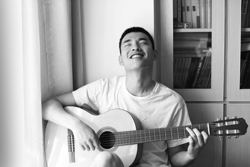 asian man playing guitar